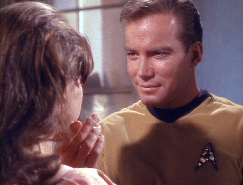 Kirk holds Miri's chin and looks at her face