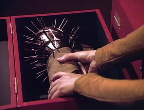 Yar picks a spiked glove out of a box