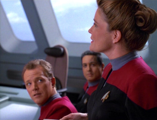 Janeway talks to her senior staff in the conference room