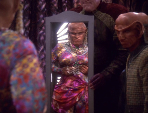 Quark examines his new body in the mirror