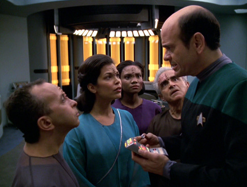 Group of Qomar stare at The Doctor in Sickbay