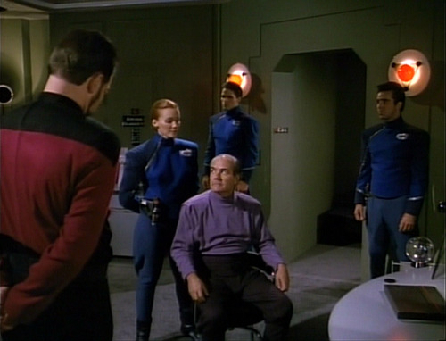 Davos interrogates a man while Riker watches