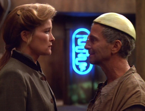 Janeway and Caylem, who is wearing a half-melon on his head