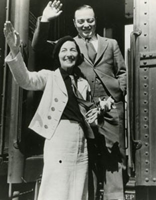 Celia Lovsky and Peer Lorre wave from the steps of a train