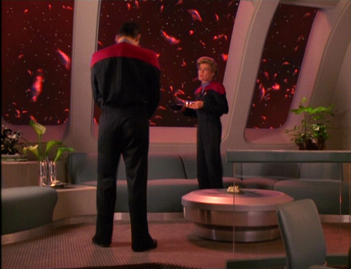 Janeway and Chakotay talk in her ready room, with spawning aliens outside