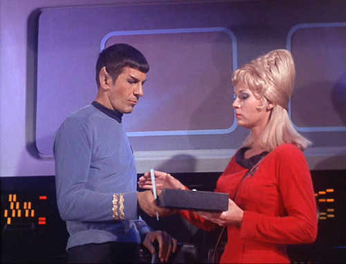 Rand gives Spock a padd to sign