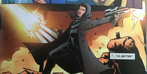 A white female Khan, in a hooded coat and all black, fires large, menacing weapons.