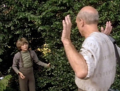Picard puts his hands up as Rene comes out of the bushes and surprises him