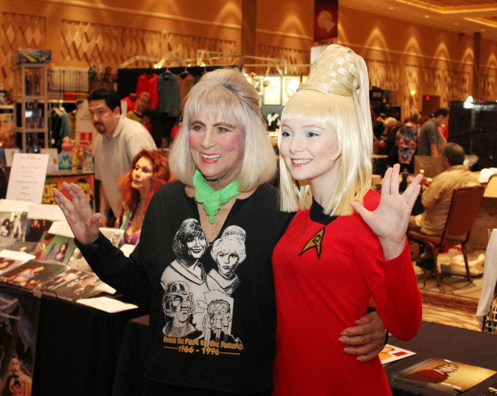 Grace Lee Whitney and a Janice Rand cosplayer give the Vulcan salute