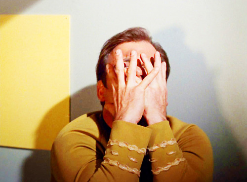 Kirk covers his face with his hands, as if in pain