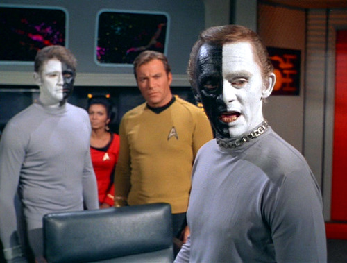 Bele and Lokai argue in front of Kirk and Uhura