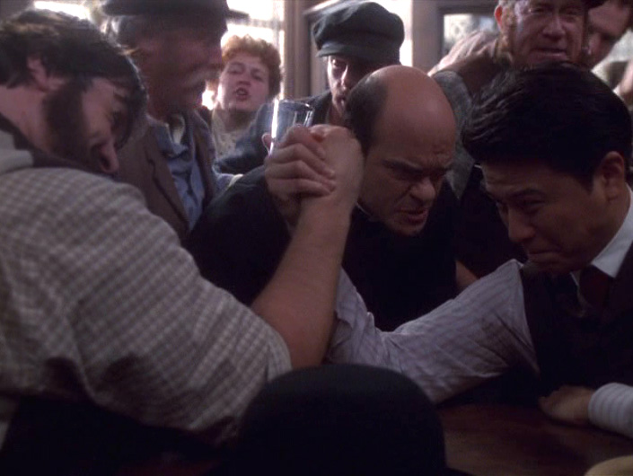 The Doctor oversees two men arm-wrestling