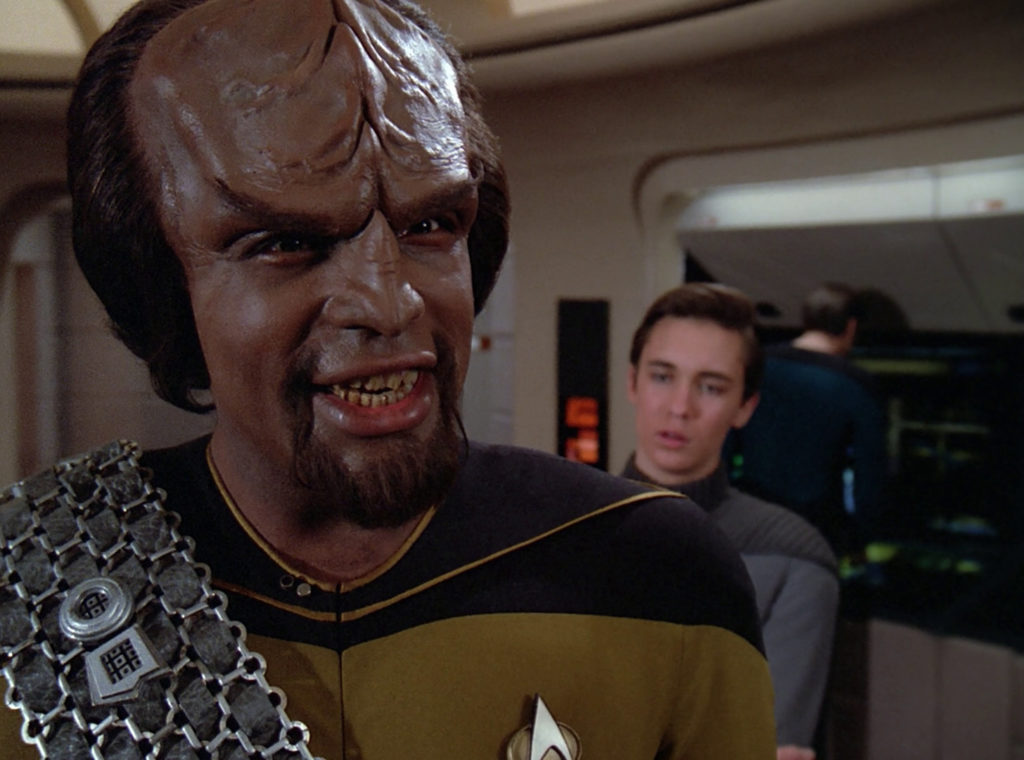 Worf talks about romancing, Klingon-style, while Wesley rolls his eyes