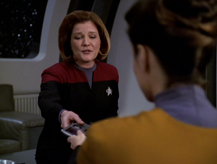 Janeway hands Celes a PADD