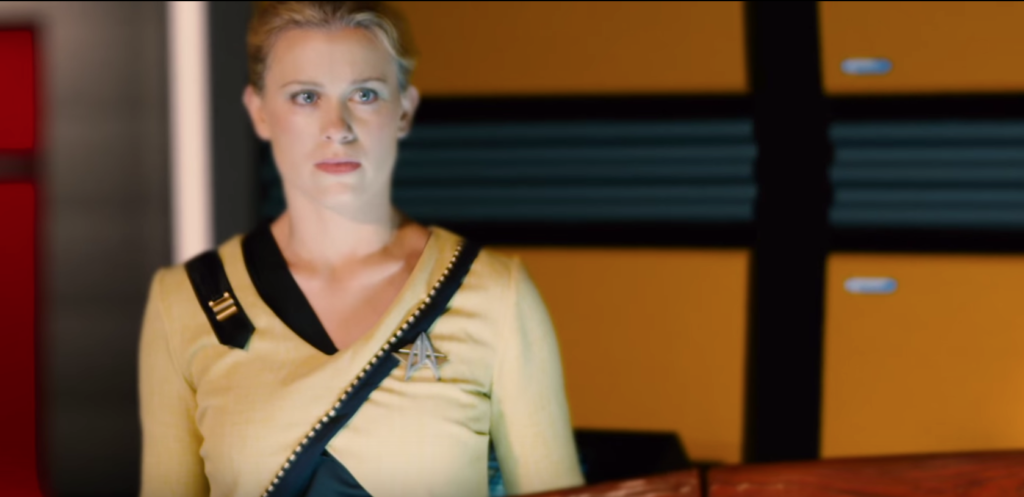Woman in her Starfleet uniform - which has black edging that crosses over her torso