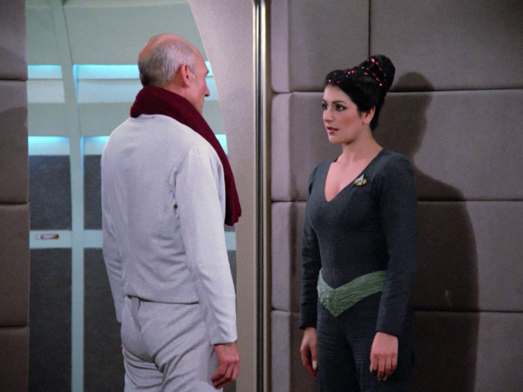 Troi speaks to Picard by the turbolift door after his fencing practice