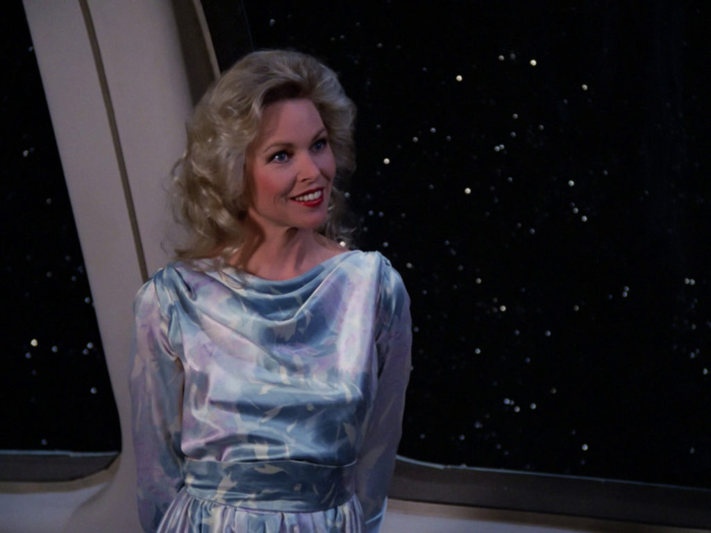 Jenice stands at the window of the Enterprise