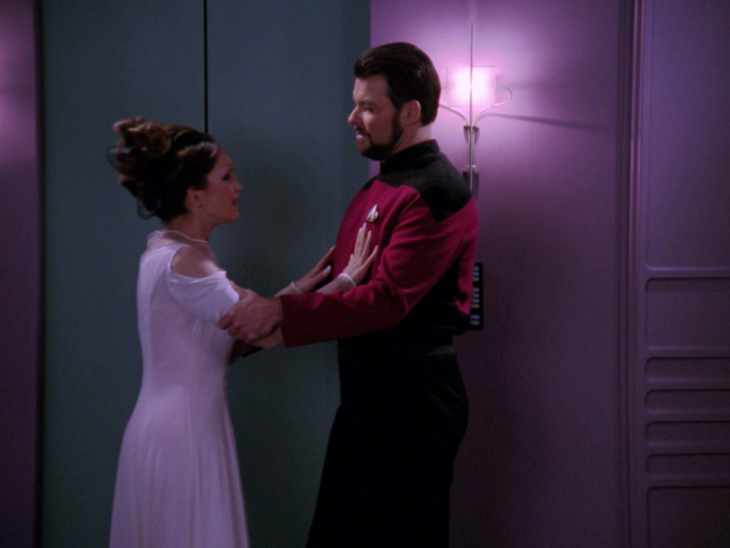 Manua tries to push Riker away as he grabs her arms