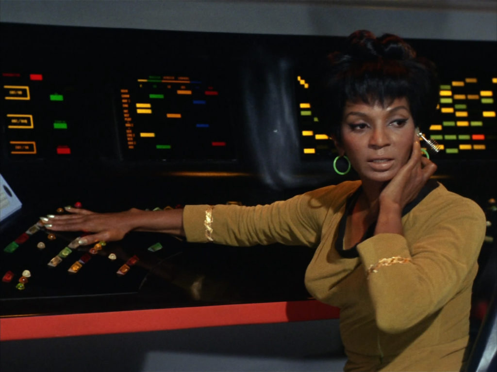 Uhura in her gold uniform at the comms station