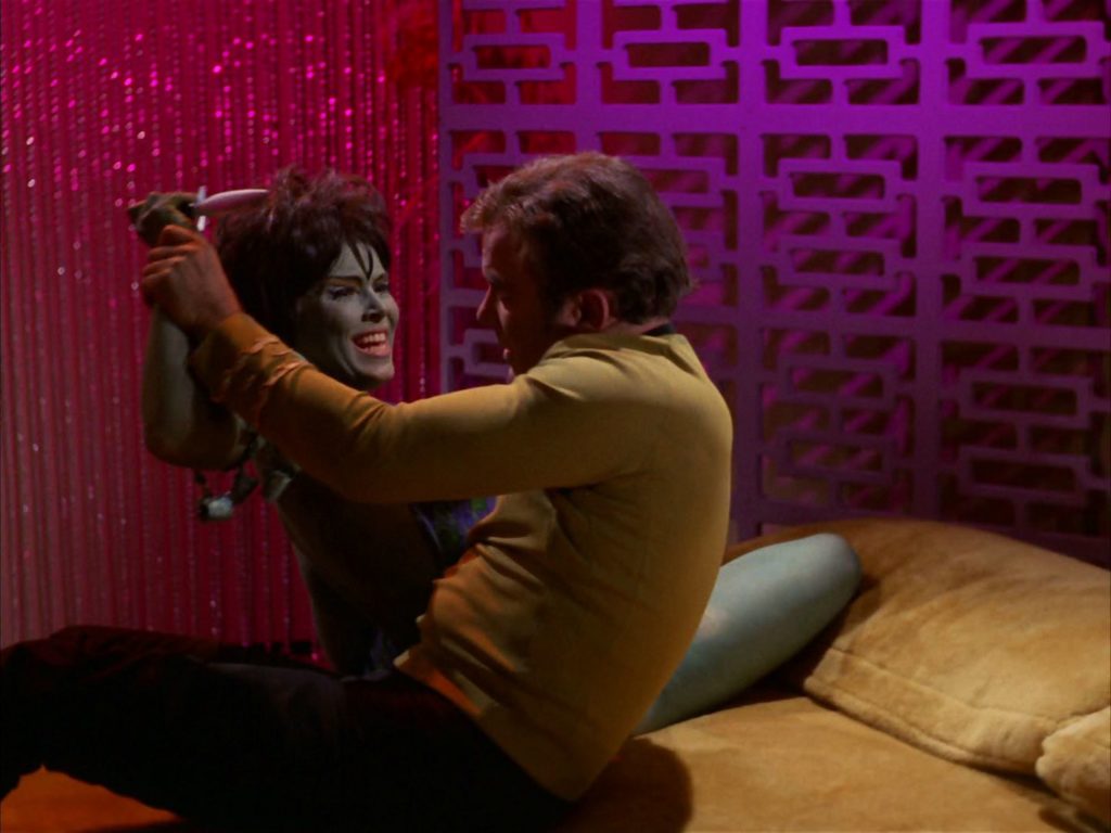 Kirk fends off Marta as she tries to stab him
